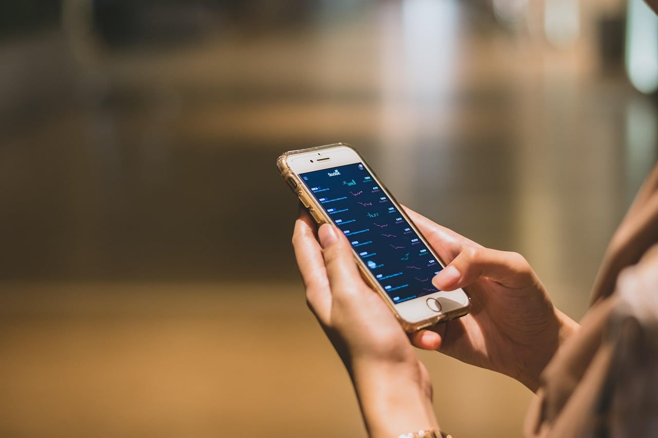 Mãos segurando smartphone com app de carteira digital aberto, ilustrando o uso do Pix por aproximação no celular